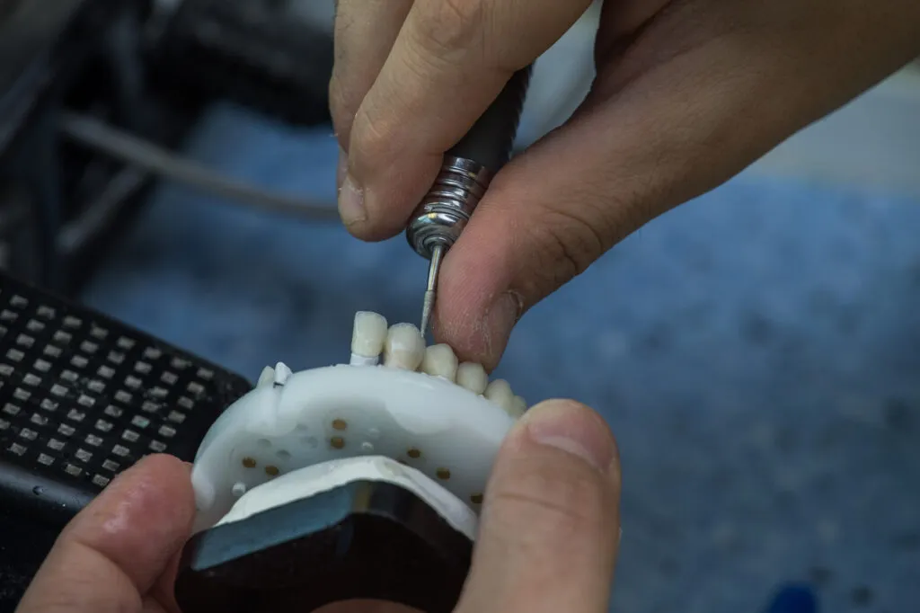 A cropped shot on a man producing a set of dentures