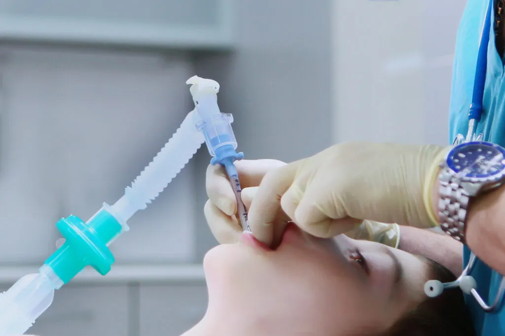 Before the dental operation a dental anesthesiologist inserts a breathing tube into the mouth