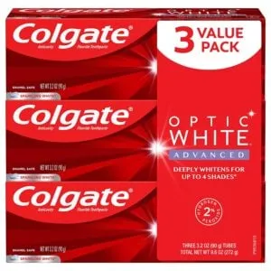 Three-pack of Colgate Optic White Advanced toothpaste. The package is red with white text and states it can whiten teeth up to four shades. Each tube is 3.2 oz, totaling 9.6 oz.