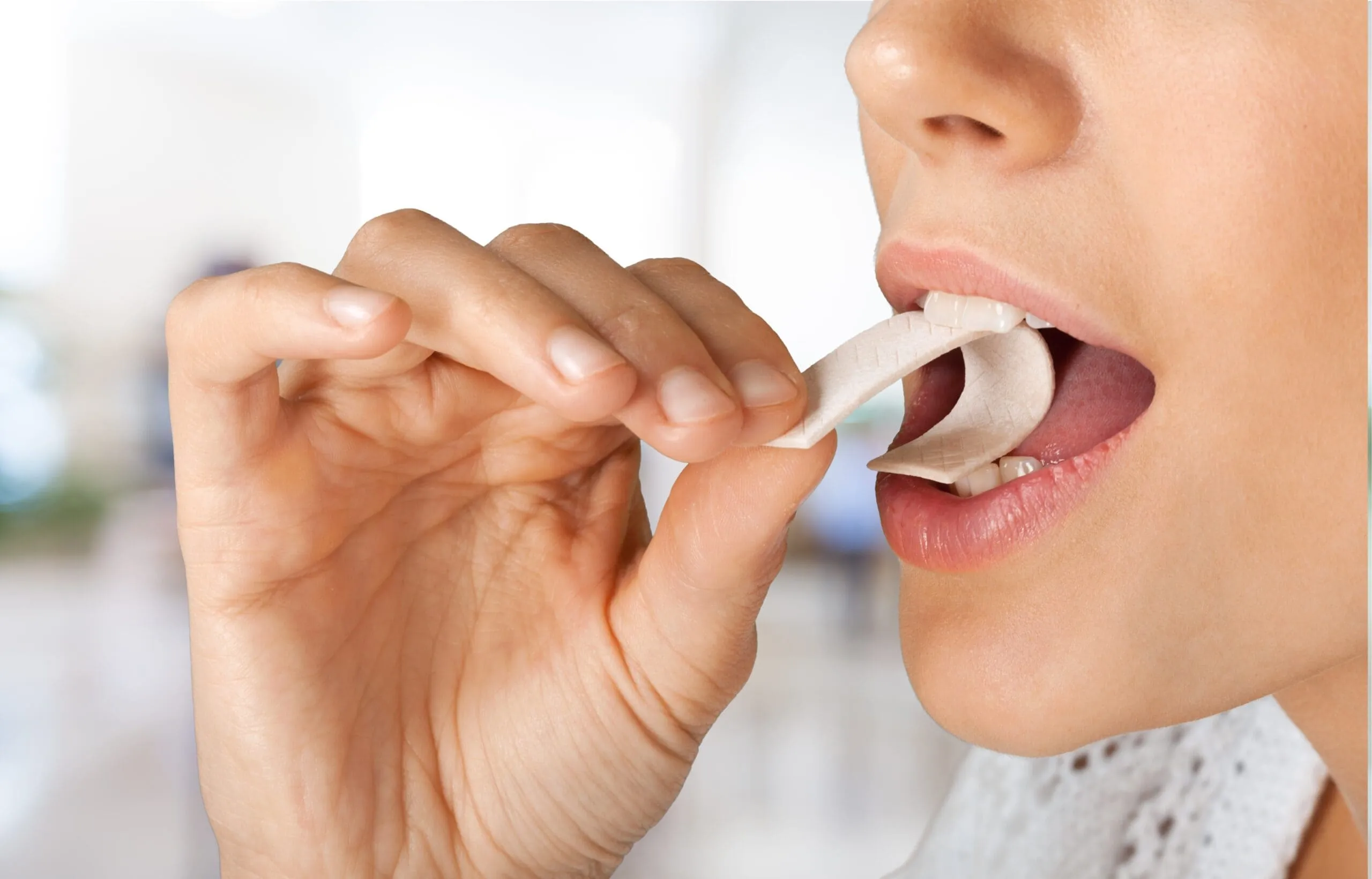 Close up shot on a woman putting a chewing gum into her mouth