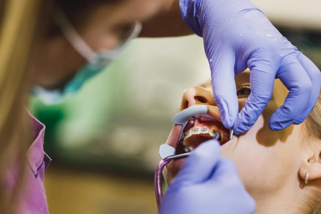 Dentist adjusting patients braces