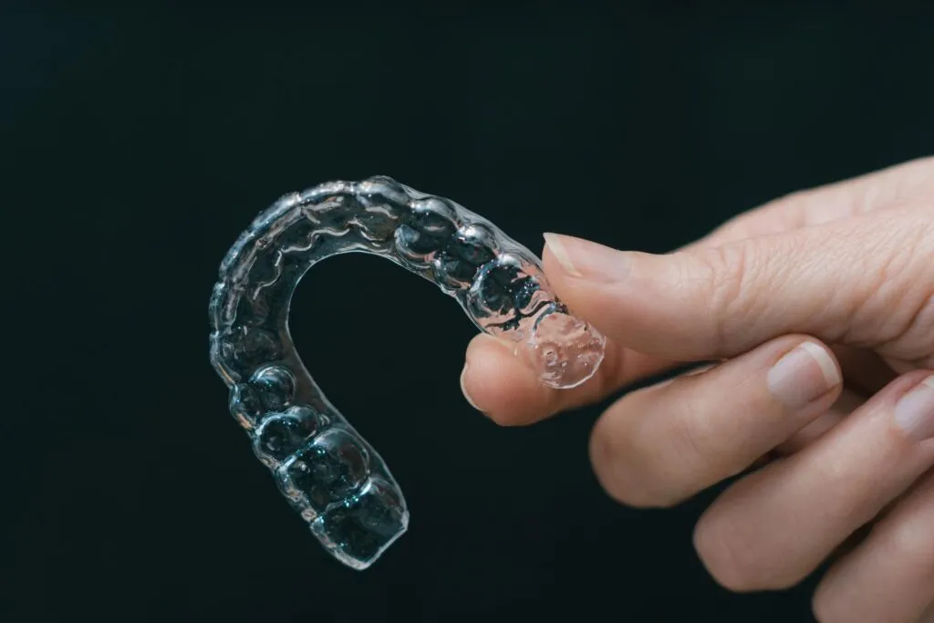 Hand holding clear aligner 1