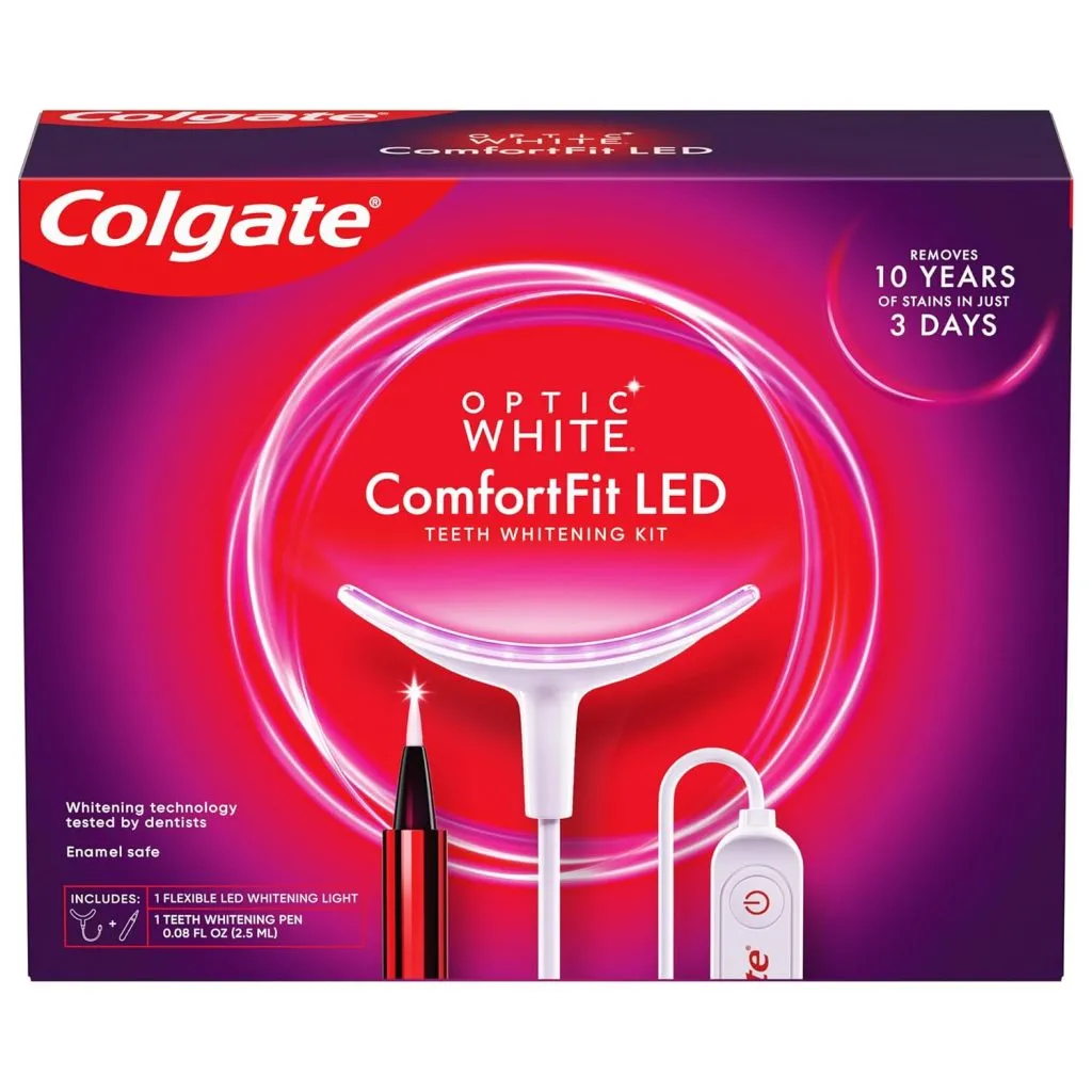 Colgate Optic White ComfortFit LED Teeth Whitening Kit box showing the device, whitening pen, and product claims such as "removes 10 years of stains in 3 days.