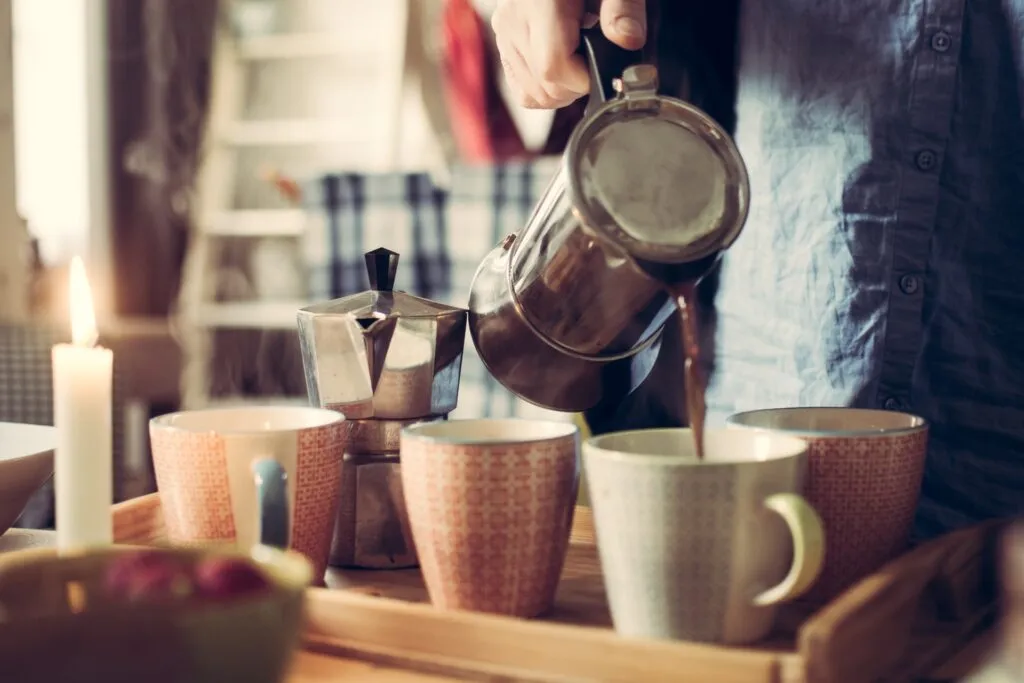 Person pouring coffee into mug