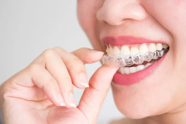 Smiling woman holding invisalign invisible braces 43937 94