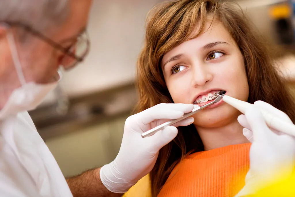 Teenage girl with braces visiting her dentist for a checkup