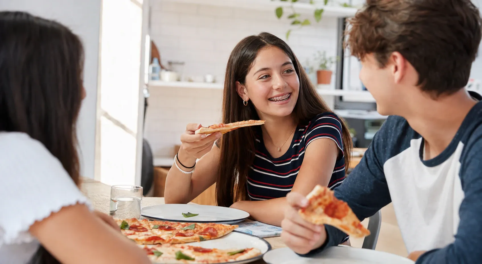 Teenage girls eating pizza with a focus on the girl with the braces nm 1166