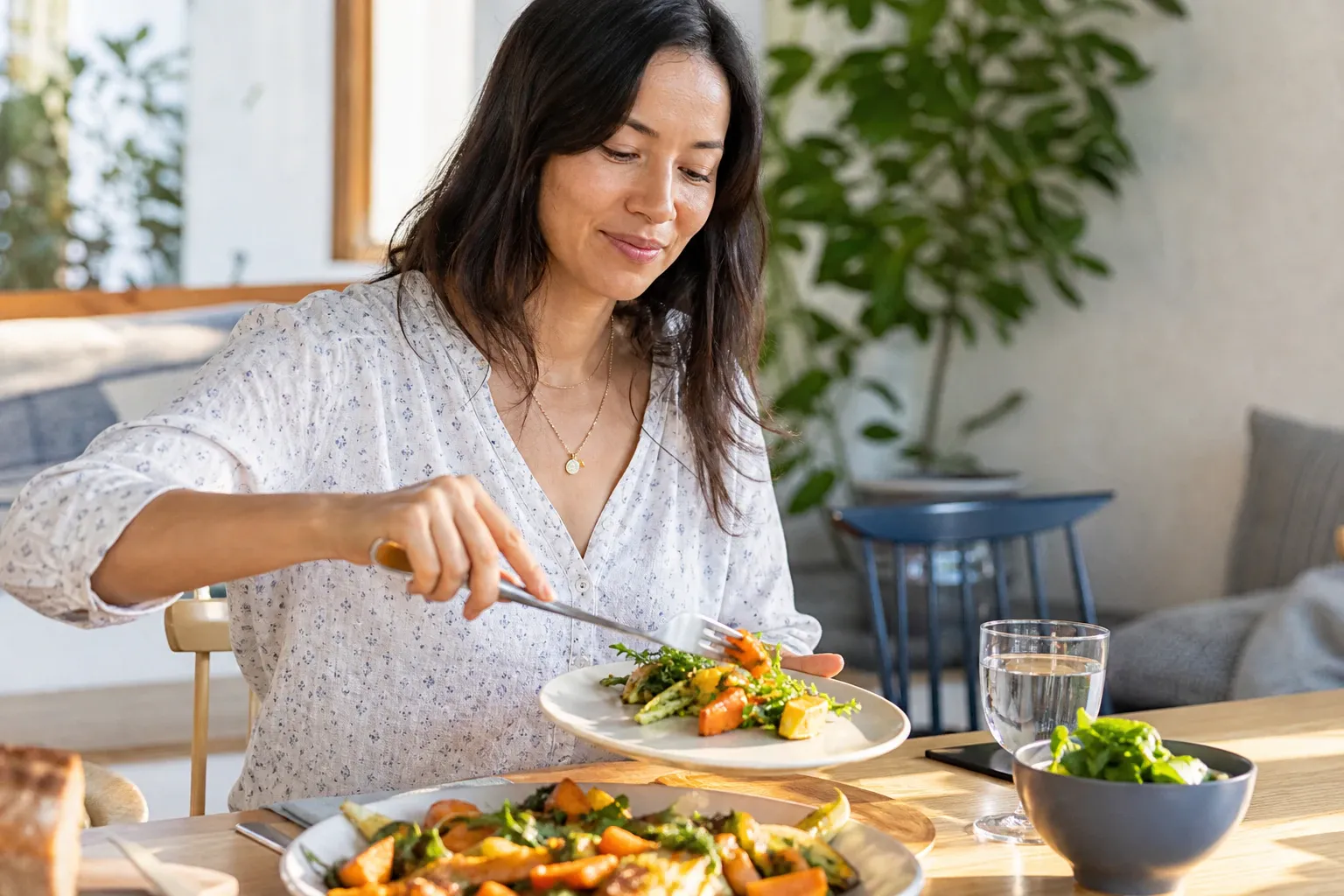 Woman getting food from a plate nm 0556