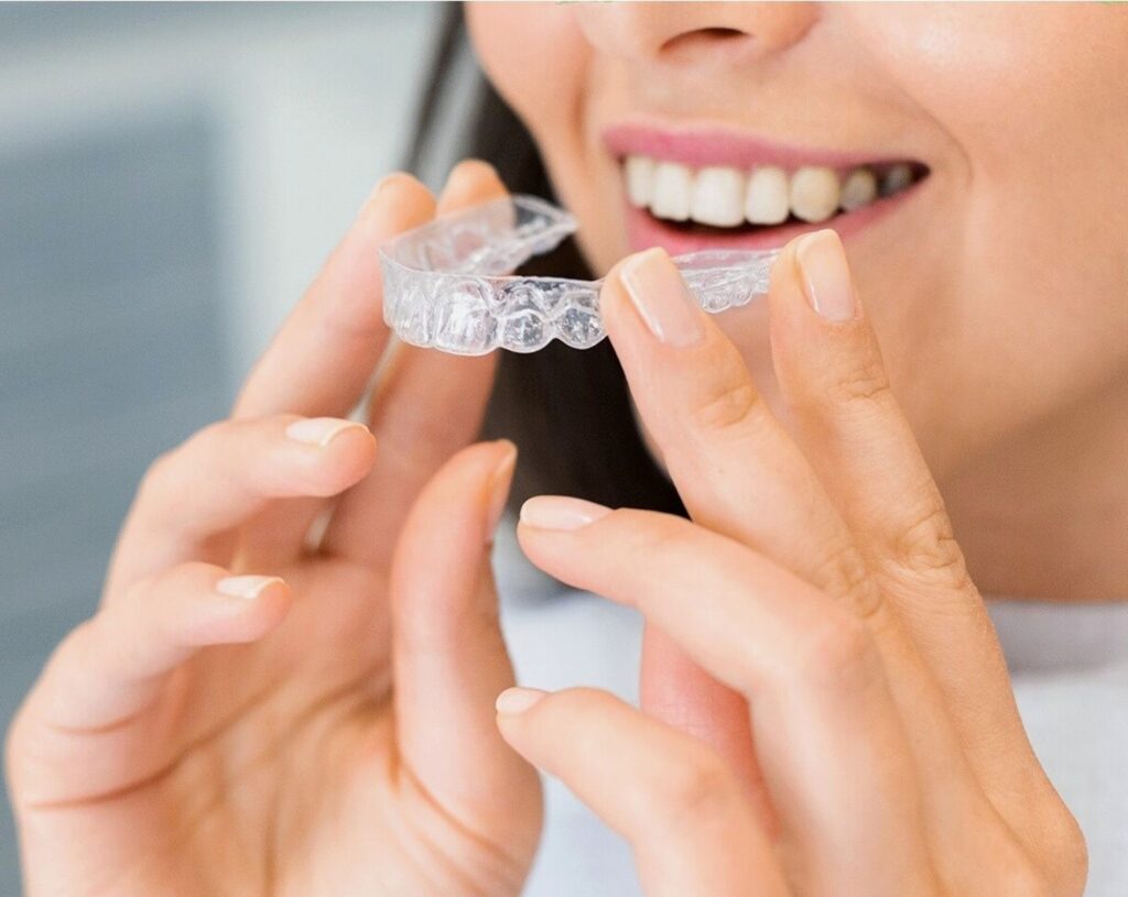 woman placing invisalign retainer