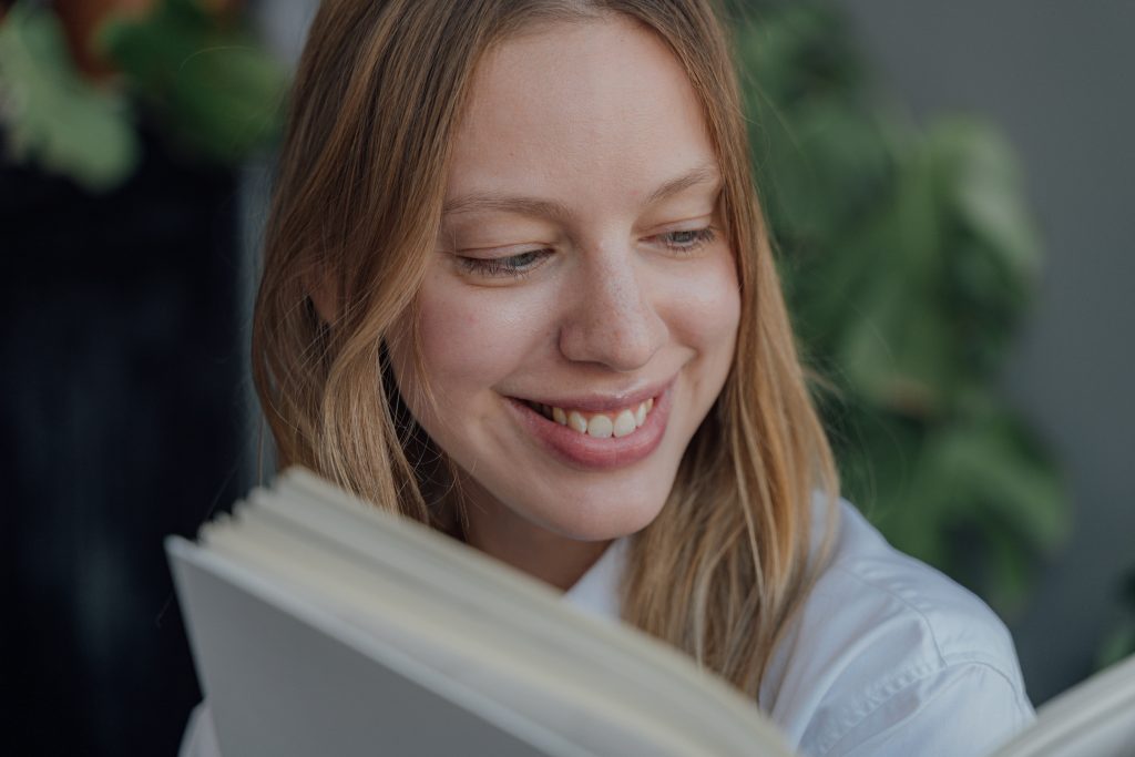 smiling young woman looking at book