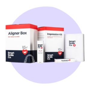 Dental kit with boxes labeled "Aligner Box" and "Impression Kit" from Smart Smile Co. Set includes transparent aligners and a small tube, placed on a white surface with a light purple circle.
