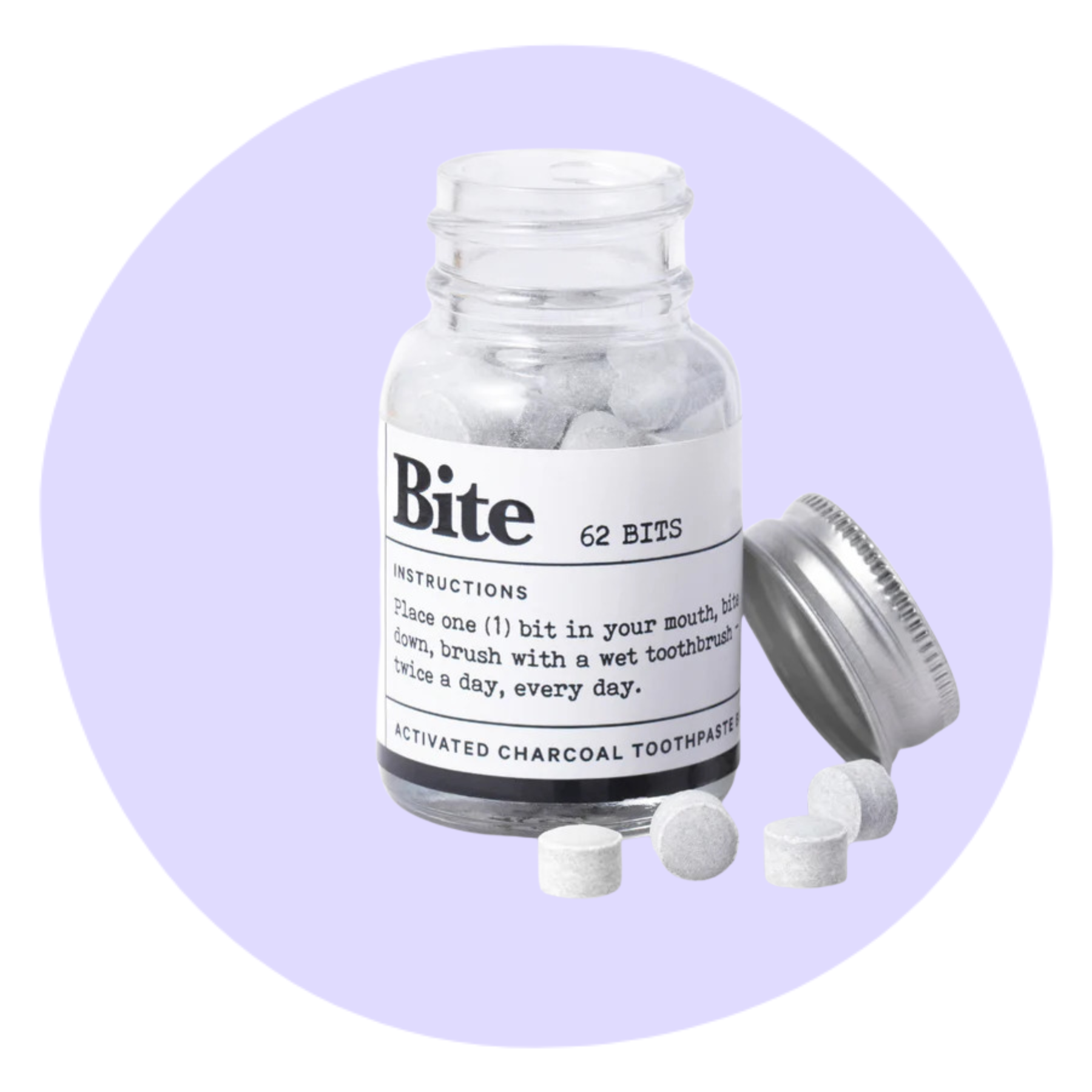 A clear jar labeled "Bite" contains 62 activated charcoal toothpaste tablets, with the lid off and several tablets on the surface beside it.